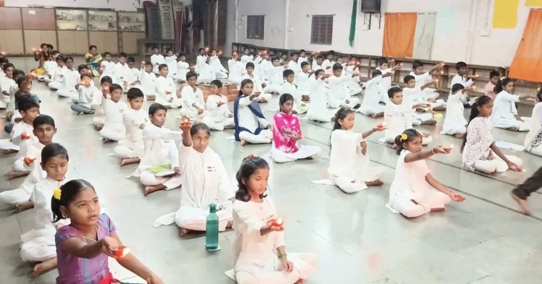 VMF students seated in prayer with lit diyas commemorating Dr. Abdul Kalam