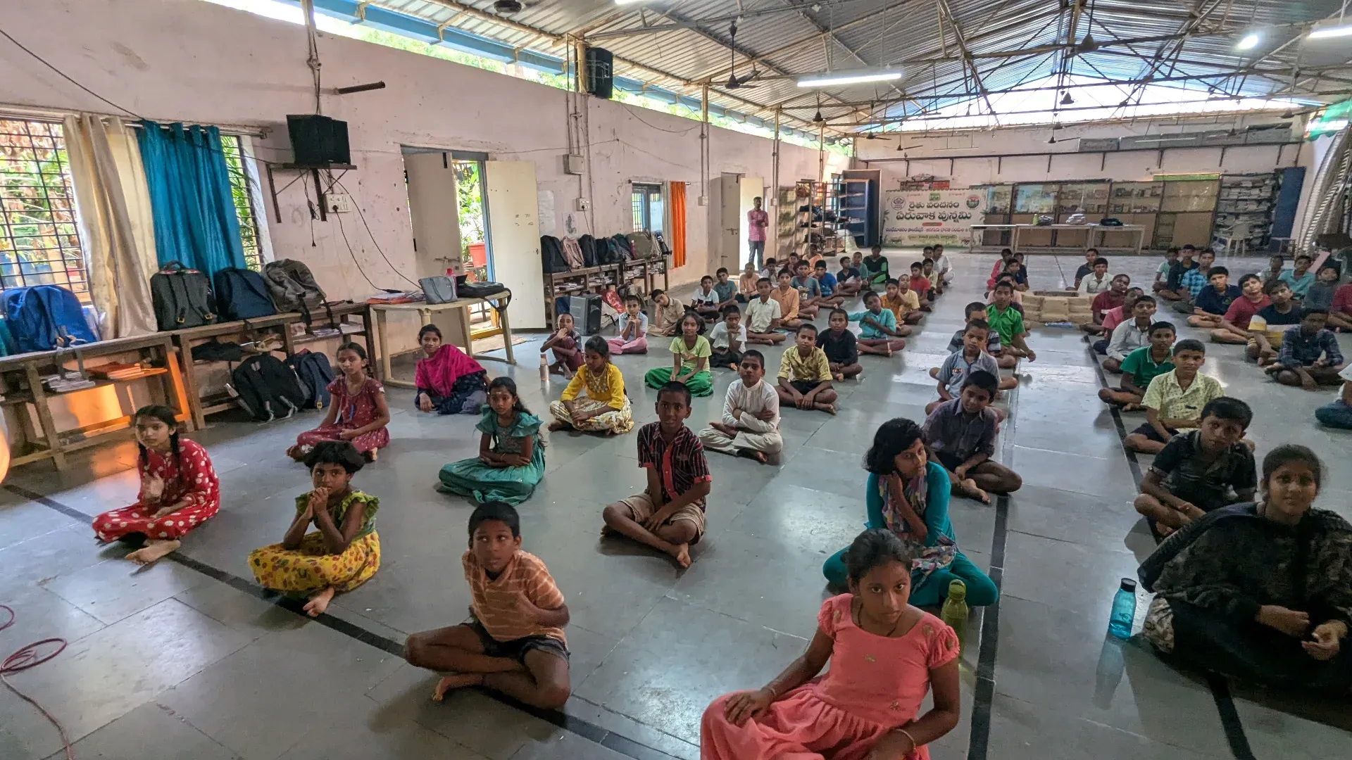 Rural Indian students in school uniforms meditating together at a Vandemataram Foundation residential school in Telangana